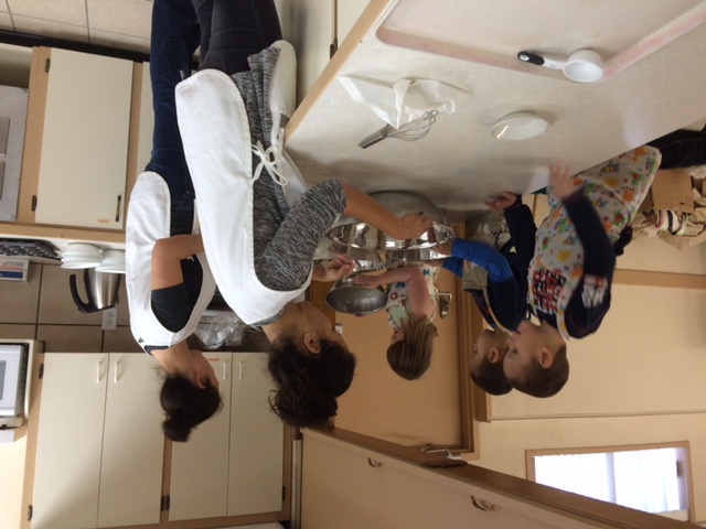 Parents and children cooking together in the DS Cooks community kitchen